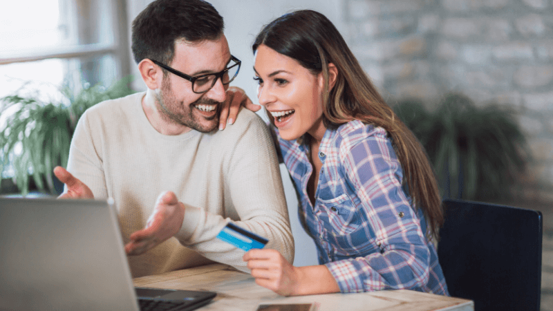 Man and woman smiling looking at laptop
